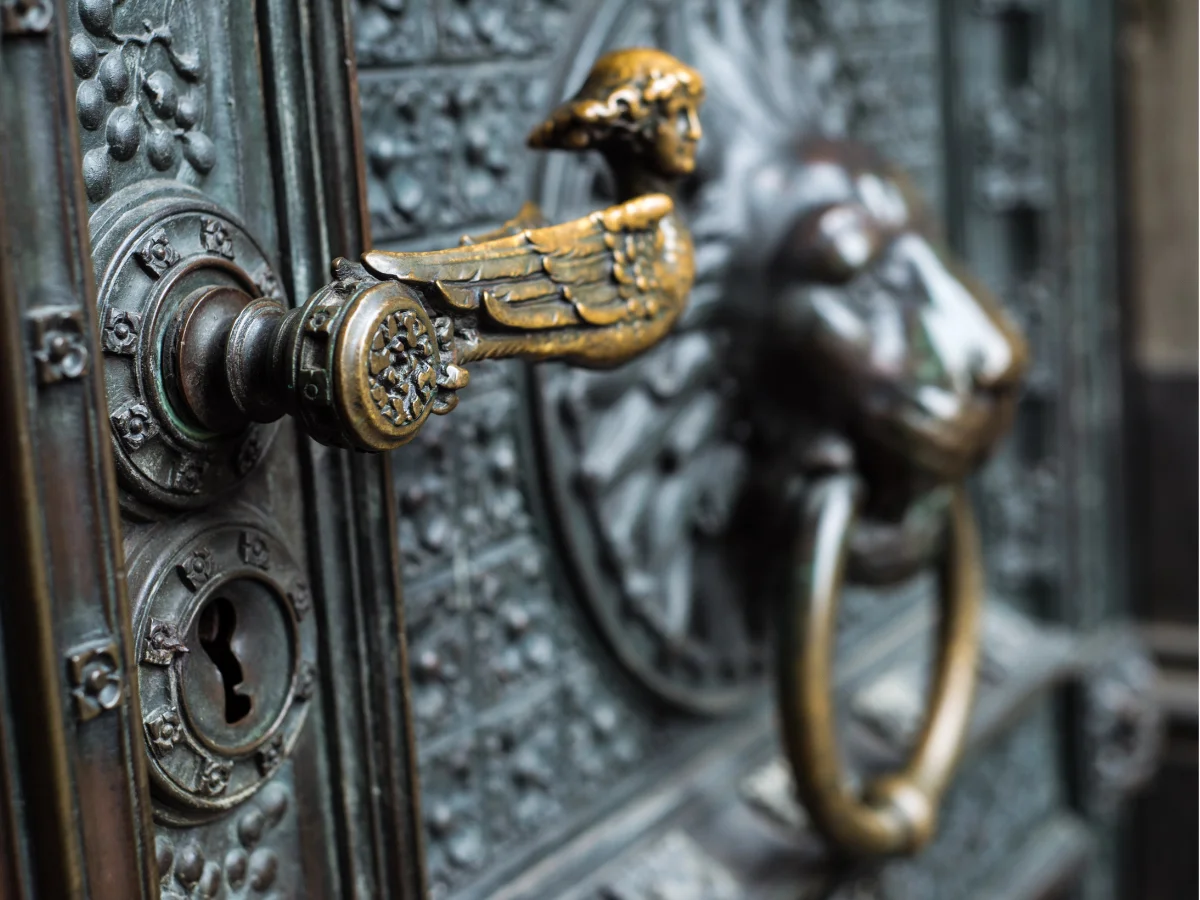 Ornate door handle and lion head knocker.