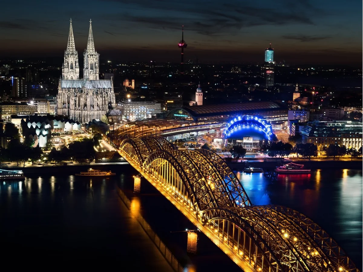 Cologne Cathedral and bridge lit up at night.