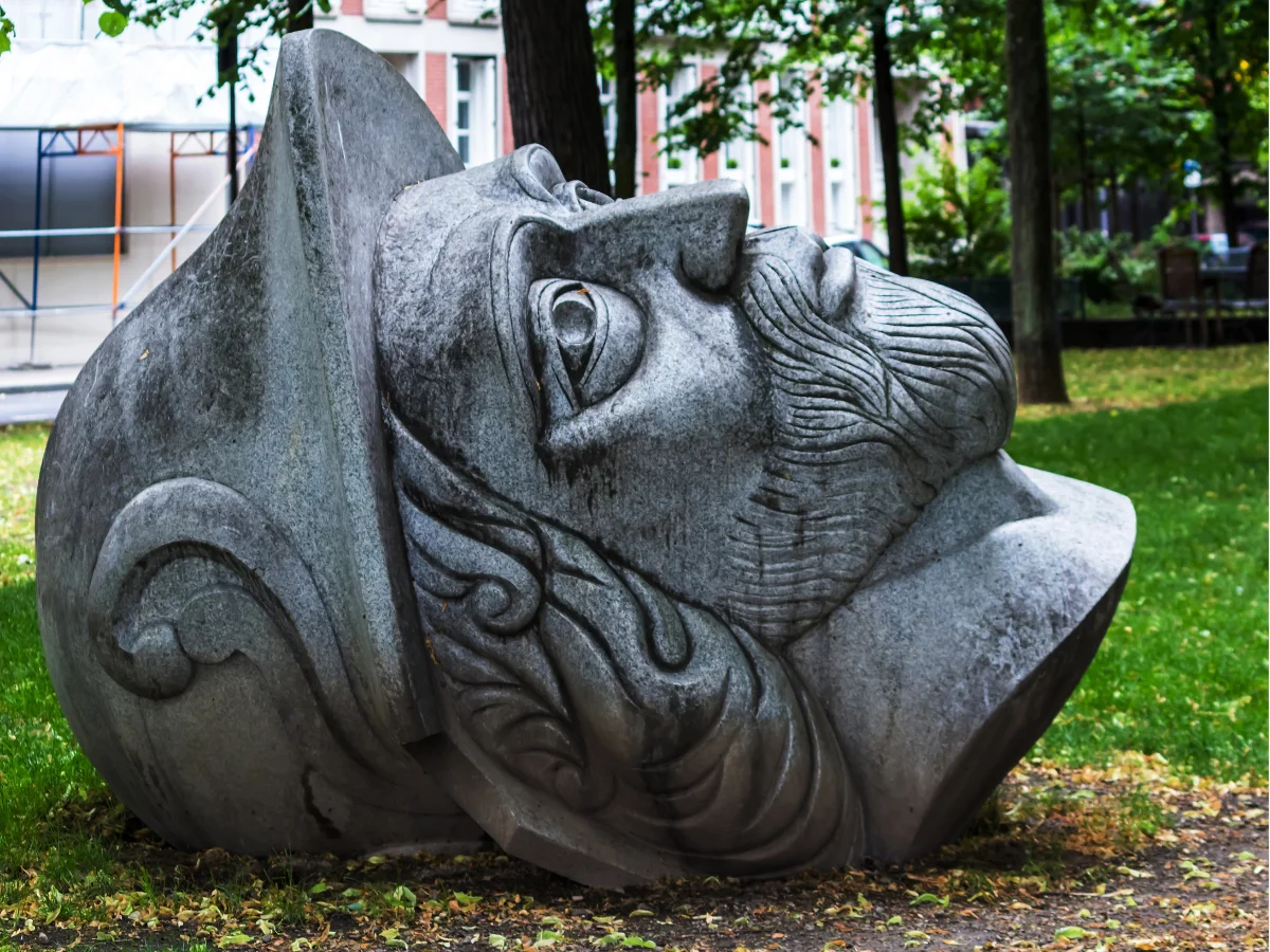 A large head of a statue lying on the ground in Cologne.