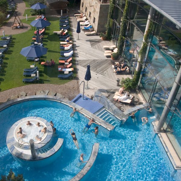 People relaxing by swimming pool and sun lounges at the Thermal Spa in Cologne, Germany