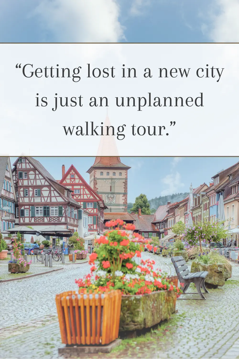 A charming cobbled street with colorful buildings and flower-filled planters. 