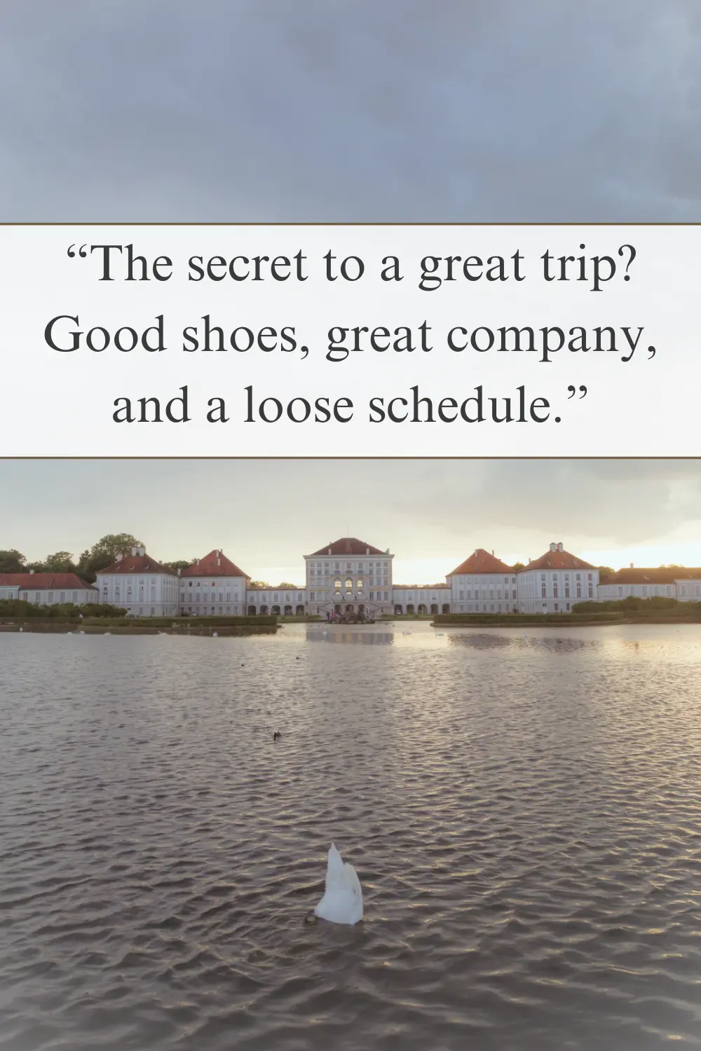 A swan floating on a lake with a grand palace in the background at sunset