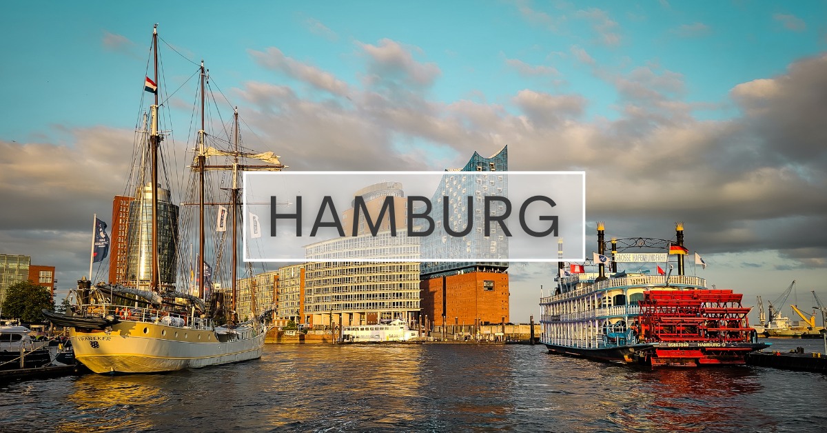 Hamburg harbour with the Elbe Philharmonie, three-masted white ship, and paddleboat.