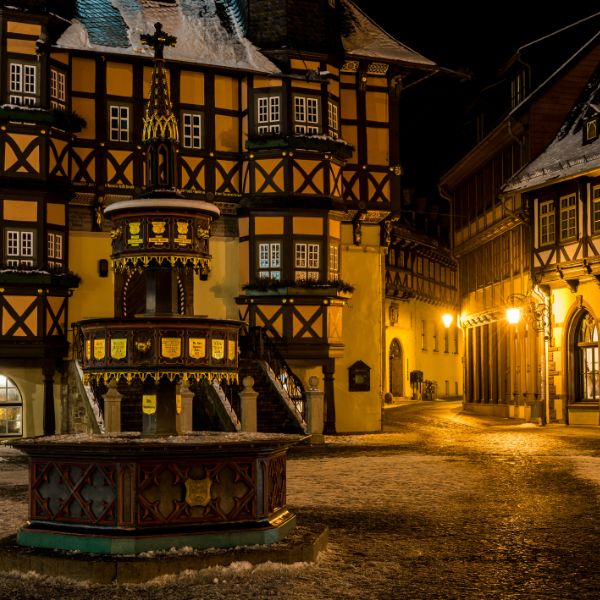 Wernigerode market square at night with fountain and half-timbered houses lit by street lights