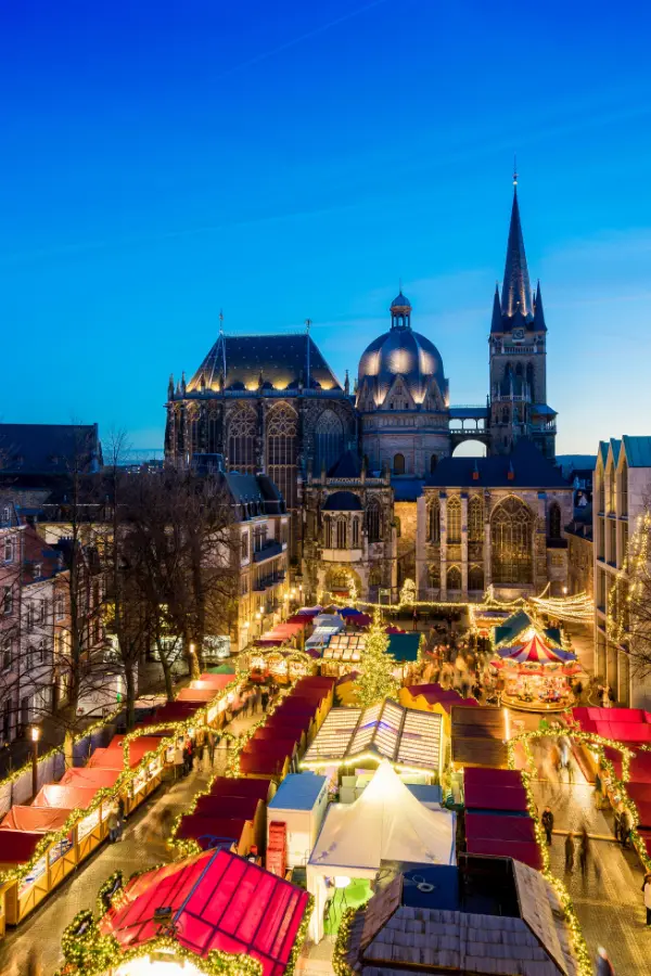 Aachen Christmas Market with illuminated stalls and a view of Aachen Cathedral