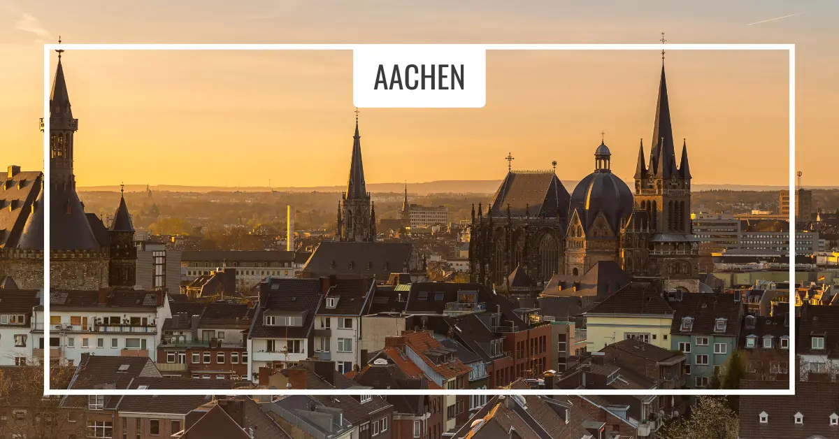 Aachen skyline with cathedral spires. Aachen cityscape at sunset showcasing historic buildings and church spires under a clear sky, viewed from an elevated angle