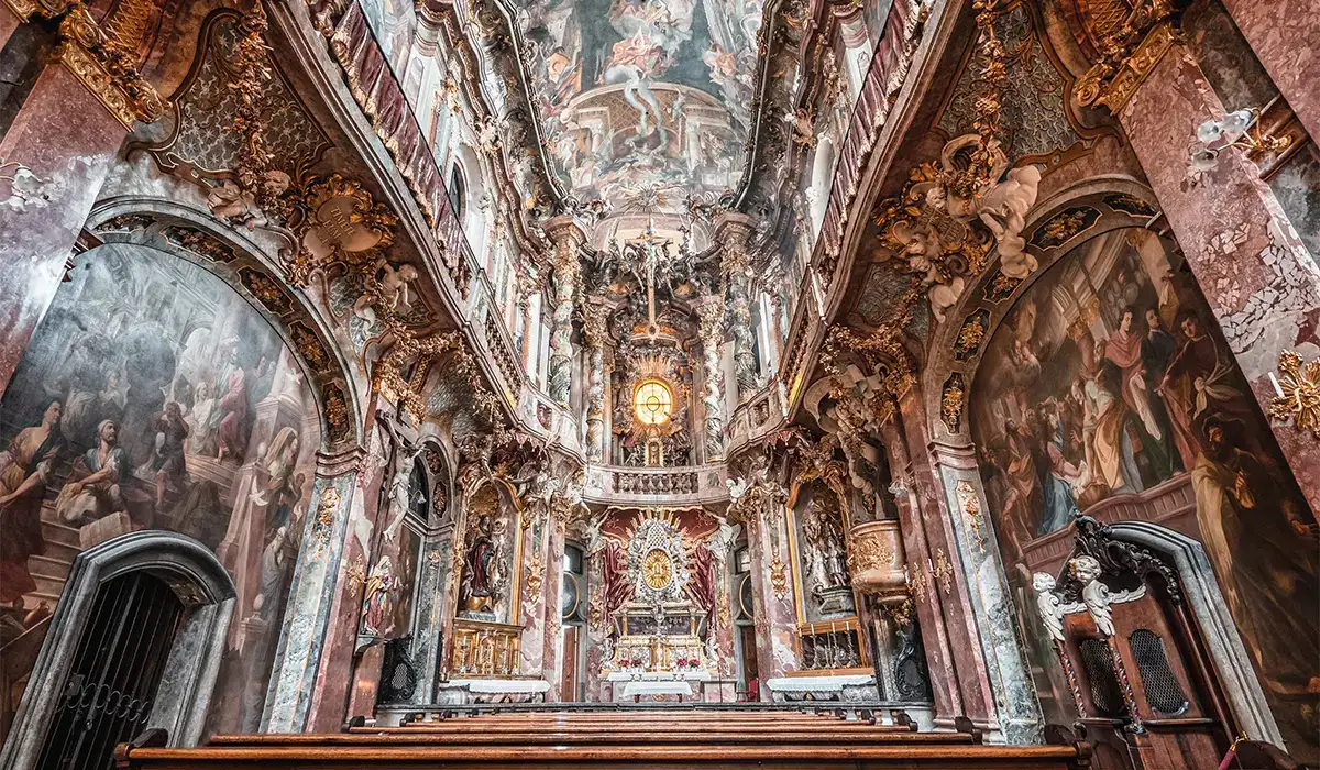 Ornate pews and baroque detail inside Asam Church, a hidden gem in Munich, Germany.