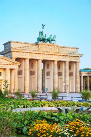 Brandenburg Gate in Berlin with colourful flowers under a blue sky