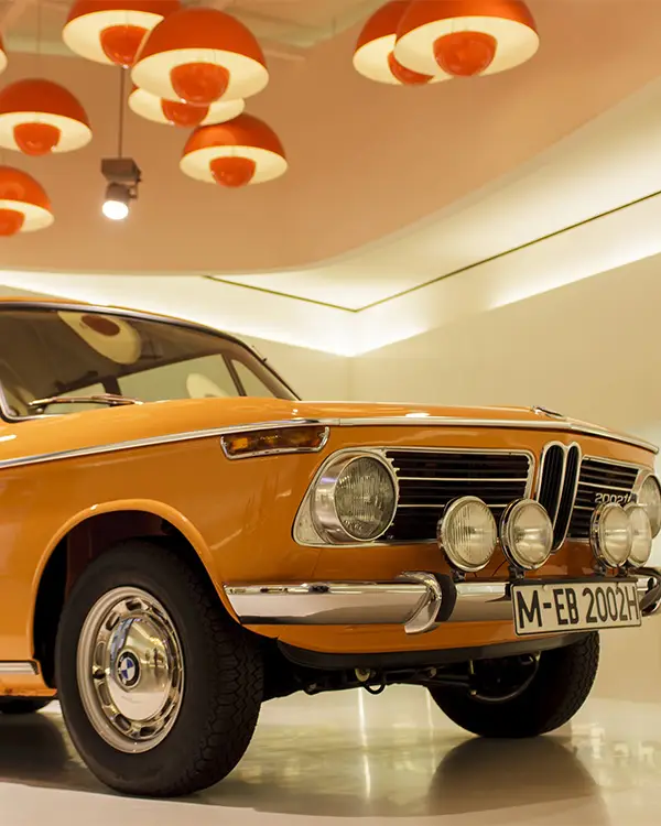 Classic orange BMW car on display inside the BMW Museum in Munich.