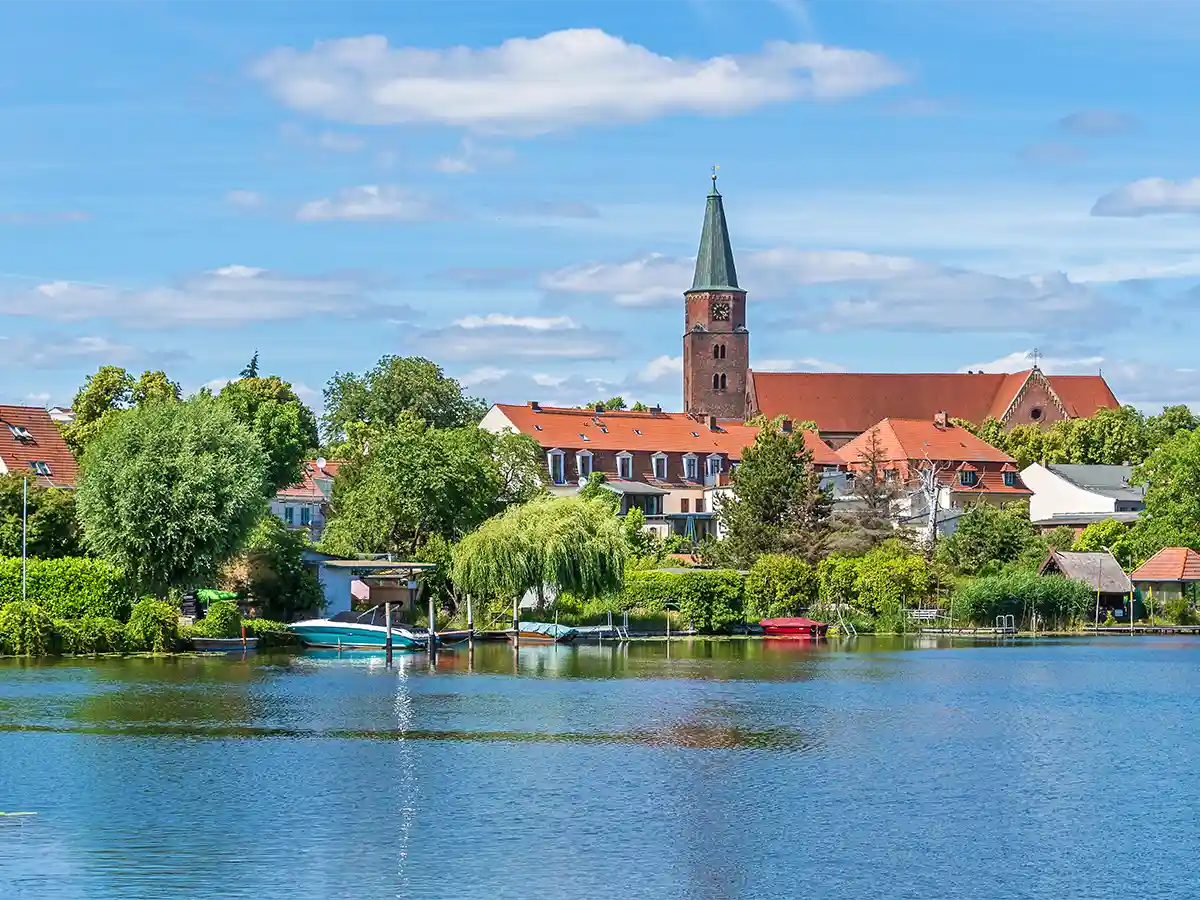 Riverside view of Brandenburg an der Havel with St Gotthardt church spire and red-roof houses reflected in the Havel—peaceful Brandenburg itinerary stop.