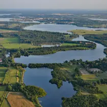 Aerial view of interconnected lakes, rivers, and green landscapes in the Brandenburg region of Germany.
