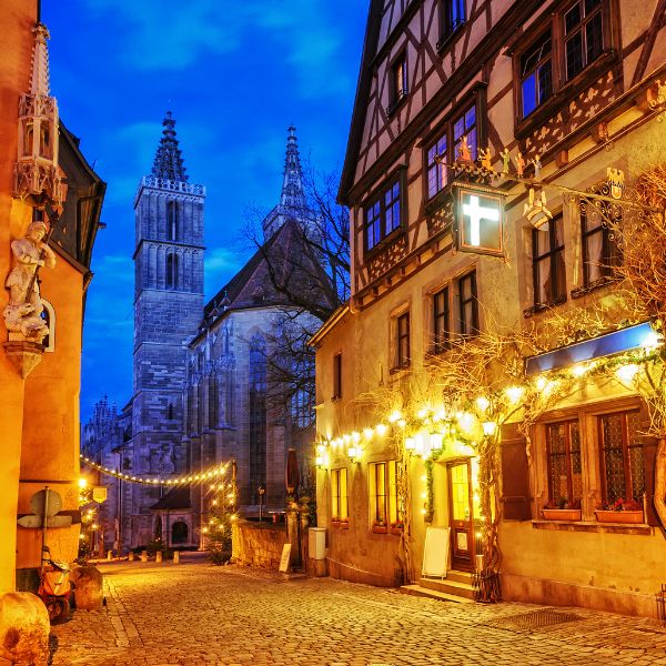 Buildings in Rothenburg, Germany lit up with Christmas lights in the evening.