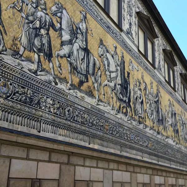 Yellow and White tile mural depicting people and horses in the Procession of Princes, Dresden