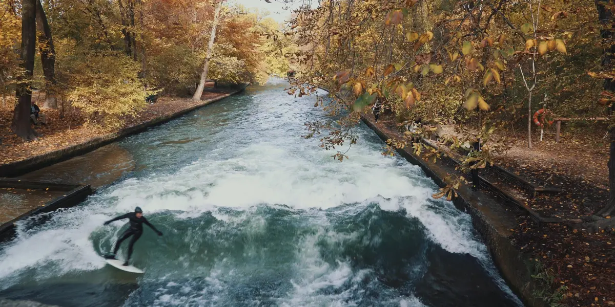 Surfer riding the Eisbach Wave in autumn