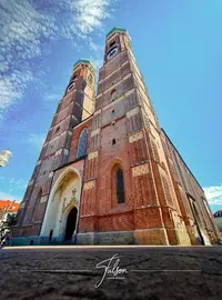 Low-angle view of a large cathedral with two tall towers under a clear blue sky.