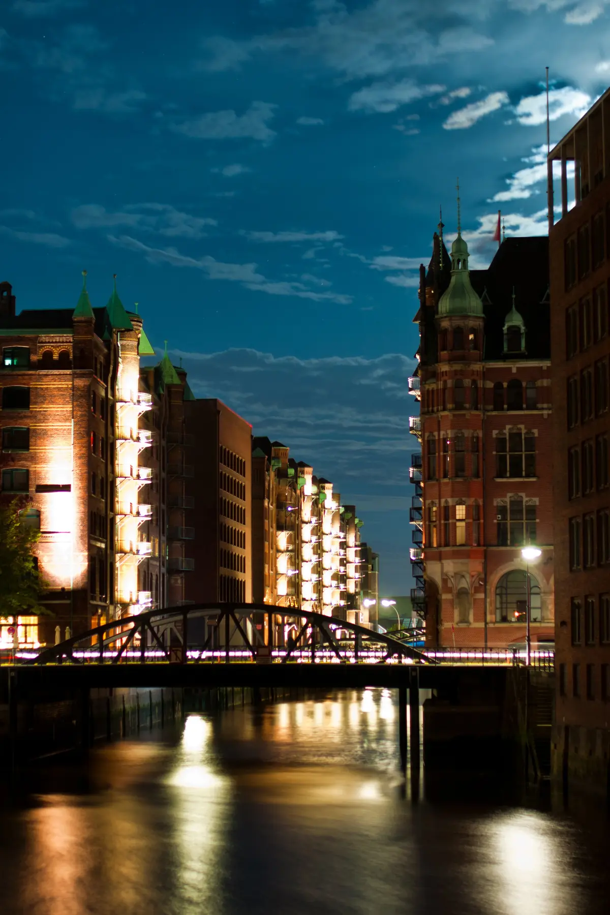 Brick buildings lit up at night along Hamburg canal