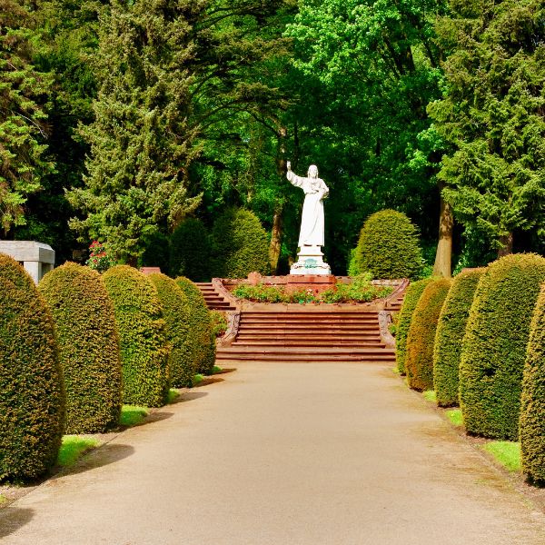 Cemetery with Jesus statue lined with shrubs