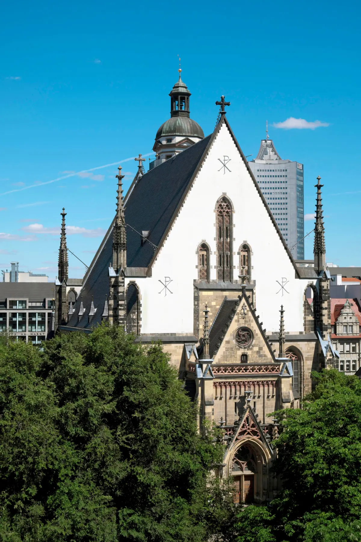 White gable and spires under a blue sky of St. Thomas in Leipzig