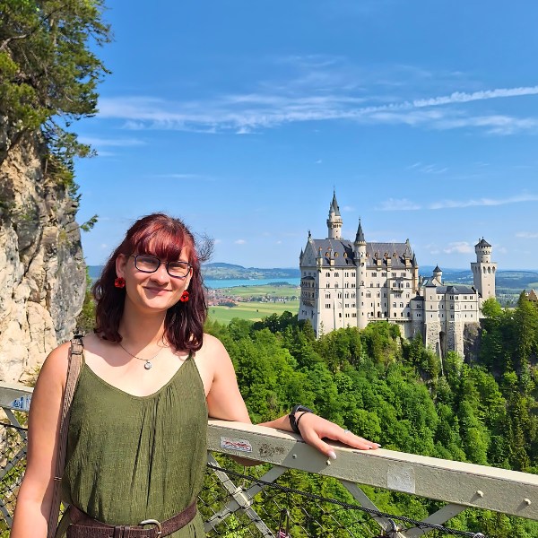 Lydia standing on bridge in front of the white Neuschwanstein Castle