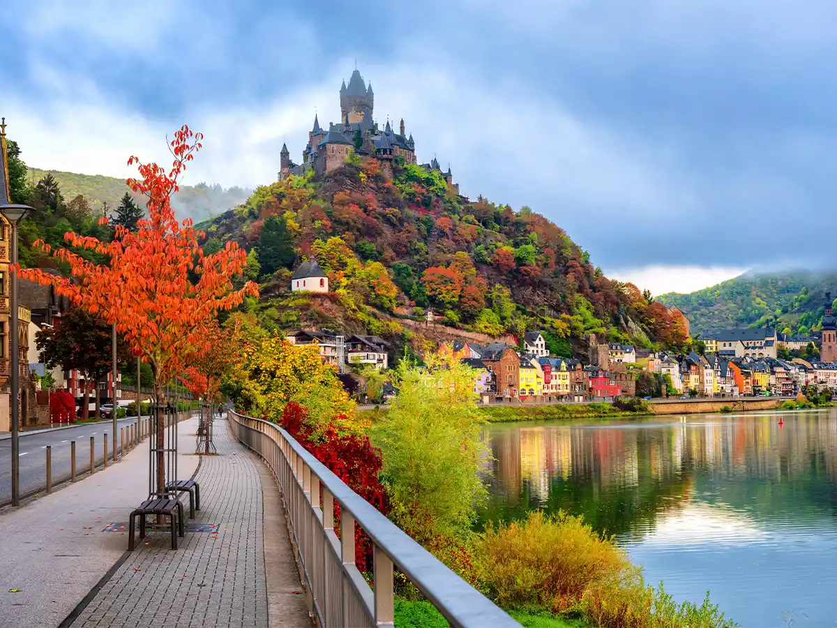 Cochem Castle overlooking the Moselle River with vibrant fall foliage in October