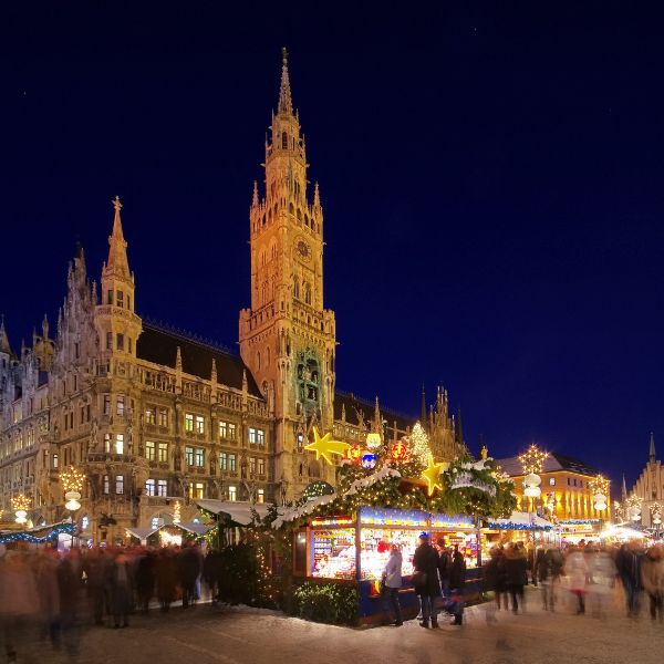 Munich Marienplatz Christmas Market with old Gothic building and market stalls lit up with christmas lights at night
