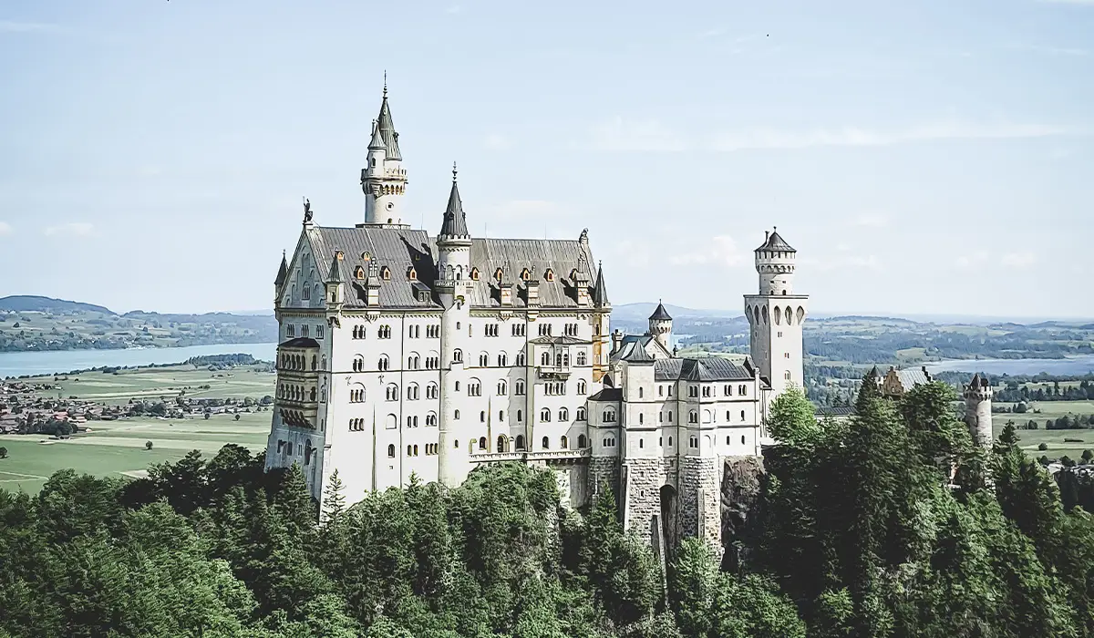 Scenic view of Neuschwanstein Castle perched on a forested hill in Bavaria, near Munich.