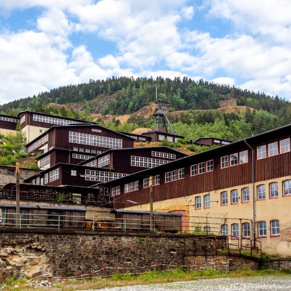 Mines of Rammelsberg, Germany brown buildings with tree topped hill behind: Mines of Rammelsberg, Germany