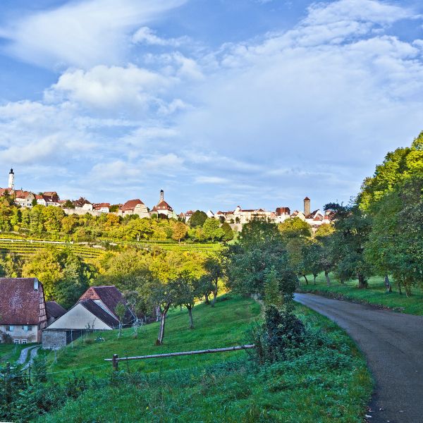Romantic Road winding through trees and meadow heading towards Rothenburg, Germany
