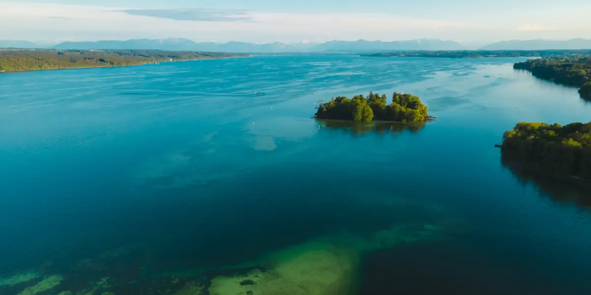 Aerial view of Rose Island surrounded by water and forested mainland
