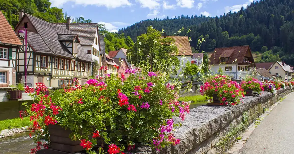 Colorful flower boxes lining a stone bridge in the half-timbered village of Schiltach, Black Forest, Germany.
