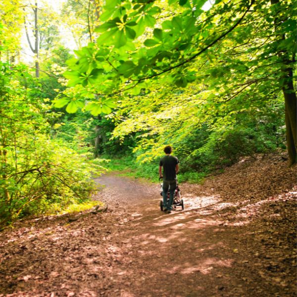 Going for a stroll - all terrain style Father pushing a baby stroller in the woods