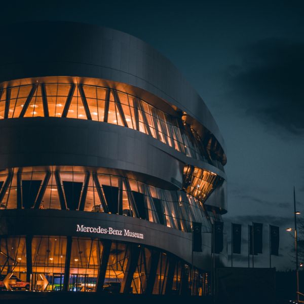 Black building and yellow-lit windows of the Mercedes-Benz Museum in Stuttgart, Germany