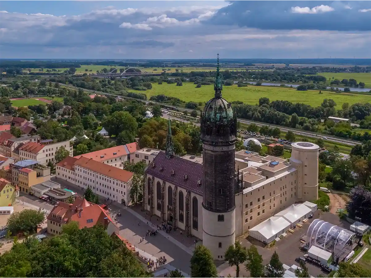Aerial of Wittenberg’s Castle Church and old town on Elbe floodplain—easy cultural side trip from Brandenburg itinerary.