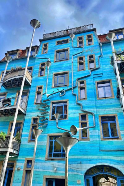 Bright blue house with series of twisting downpipes known as the Art Courtyard Passage in Dresden, Germany