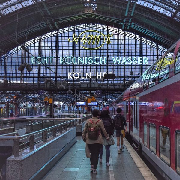 People standing next to a train on a platform in Cologne Central Train Station
