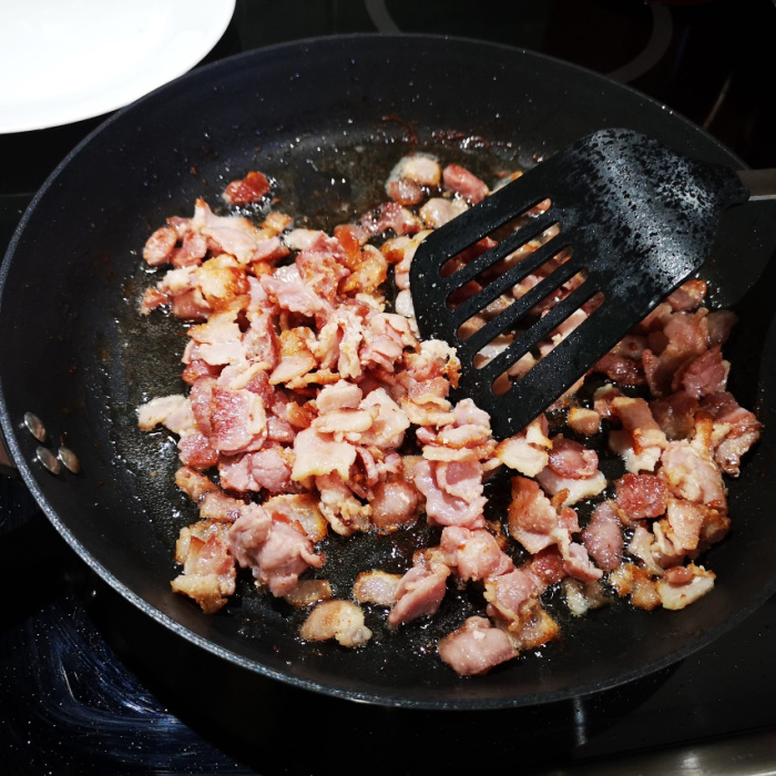 frying diced bacon in fry pan